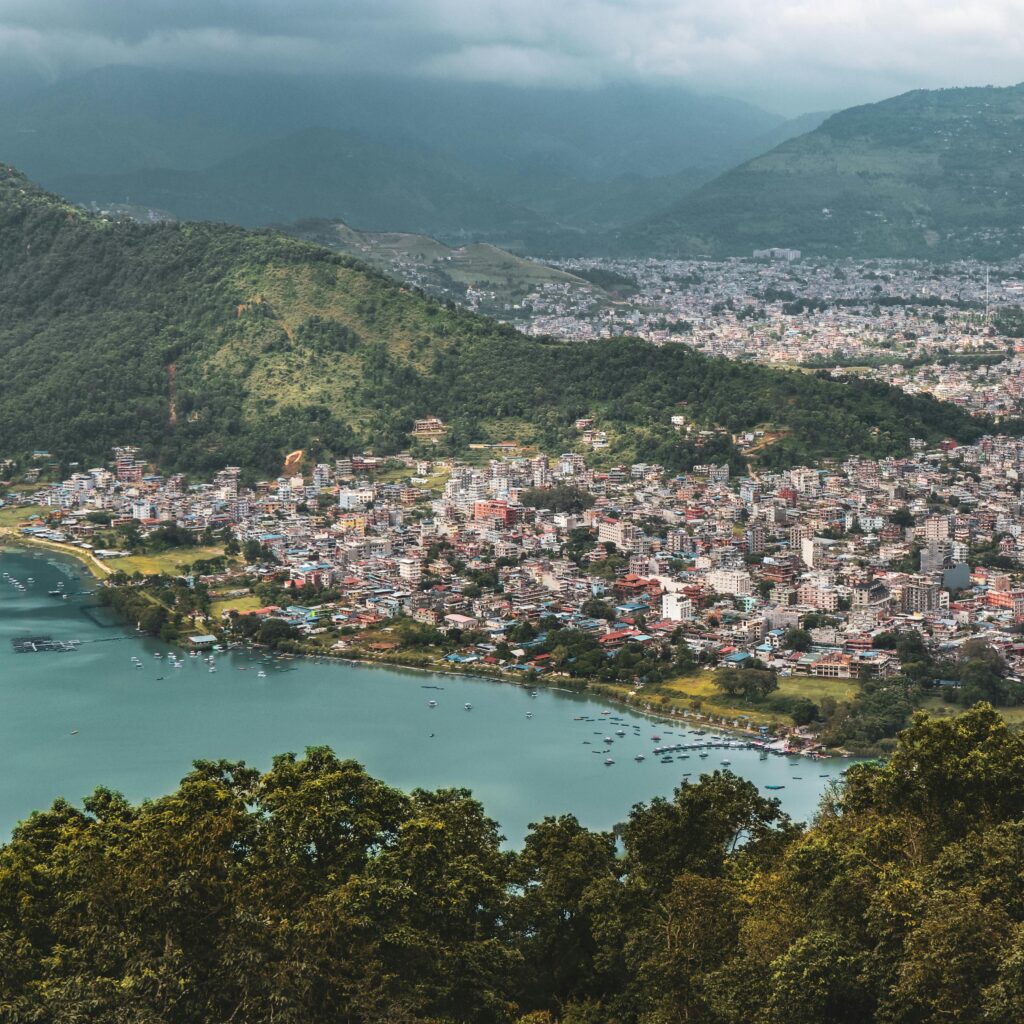 A stunning aerial view of Pokhara city and Phewa Lake surrounded by lush hills in Gandaki Province, Nepal.