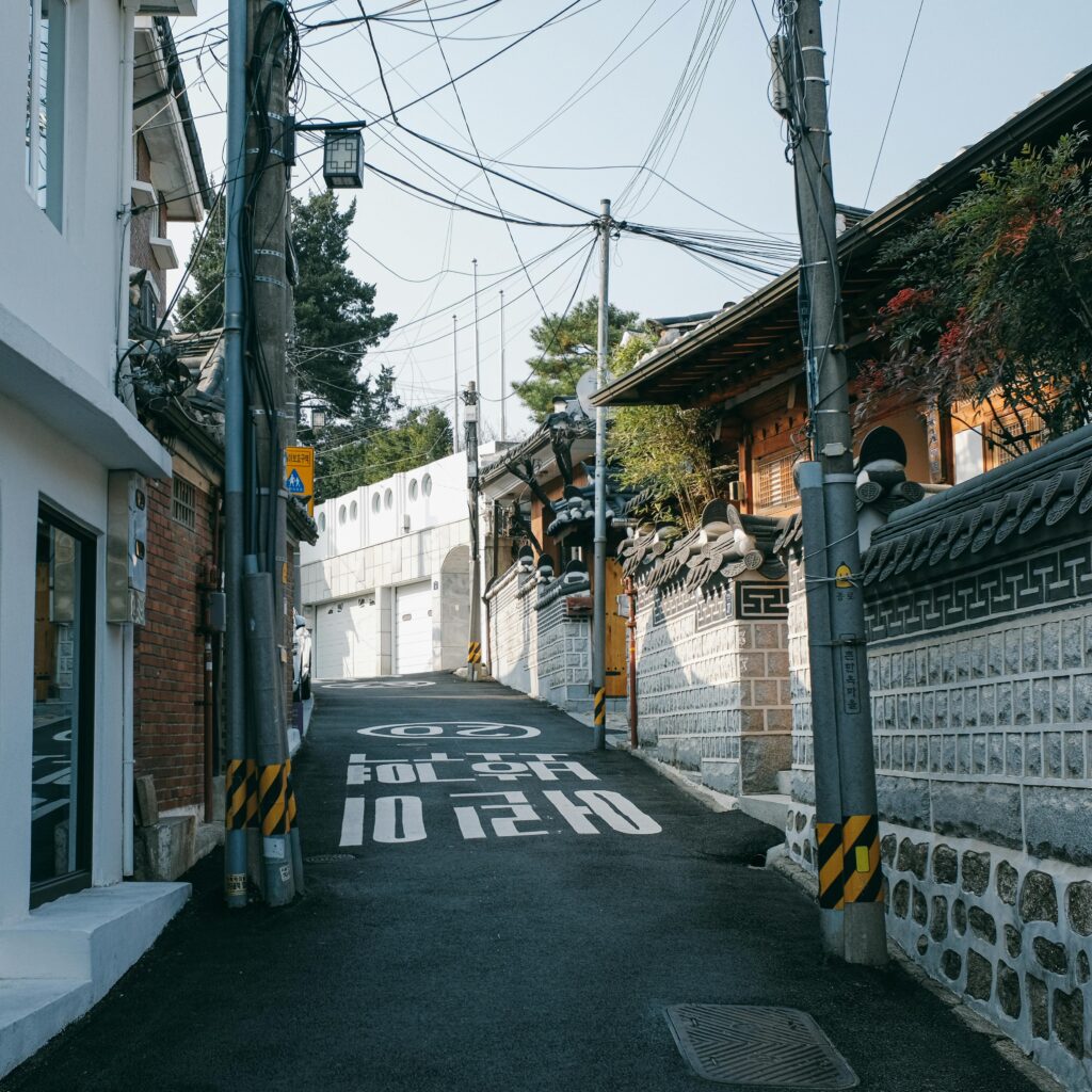 Explore a serene alley in Seoul with traditional architecture and vibrant urban charm.