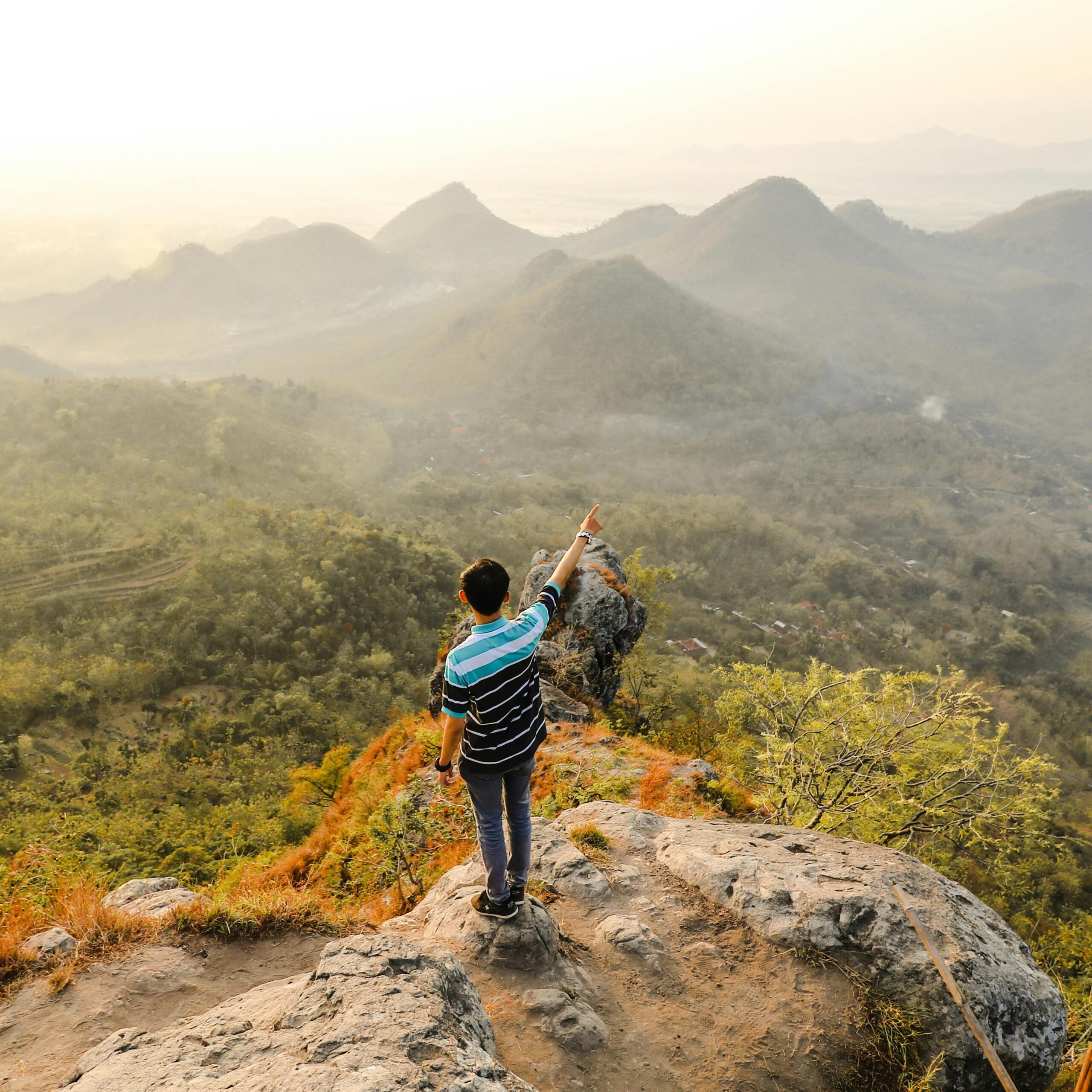 Man pointing at scenic Mandau Talawang mountains, Central Kalimantan, Indonesia.